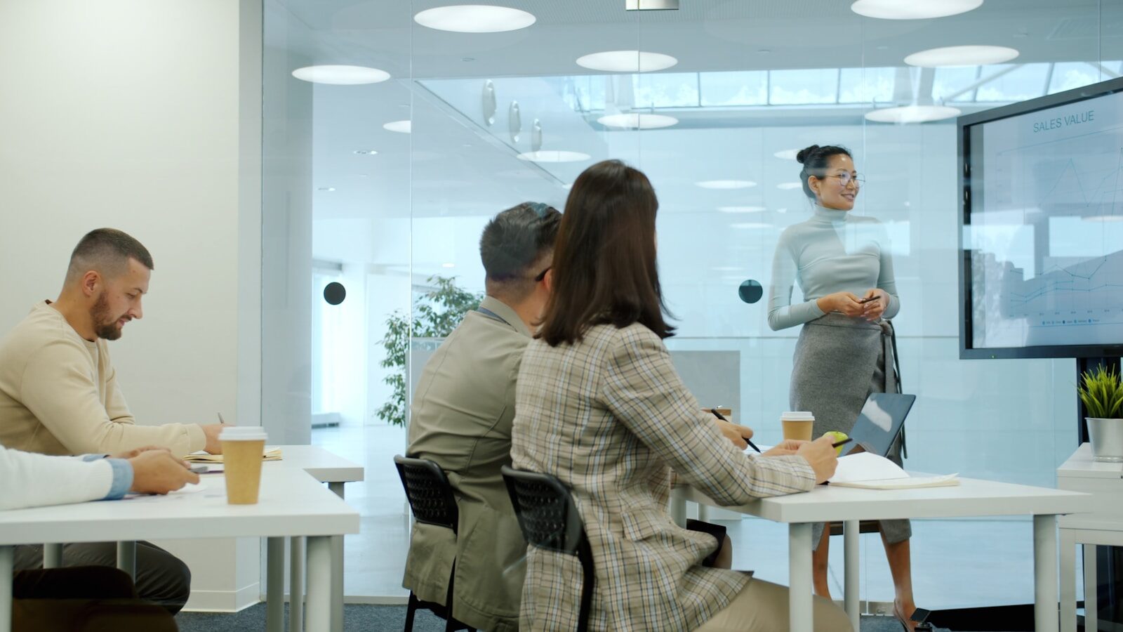 Photo by Vitaly Gariev Woman delivering training in a modern office meeting.